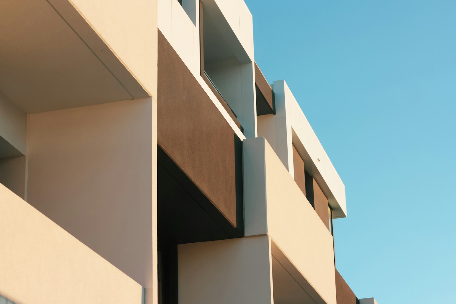 Moderne, saubere Wohnanlage mit Balkonen unter blauem Himmel
